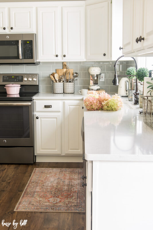 A Gray and White Kitchen with Pink Accents and Vintage Rug.