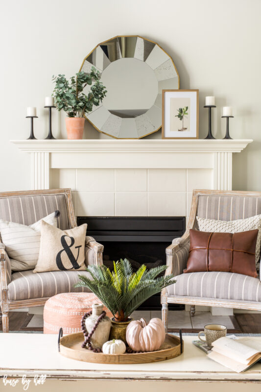 There are two chairs flanking the fireplace with pillows on the chairs.