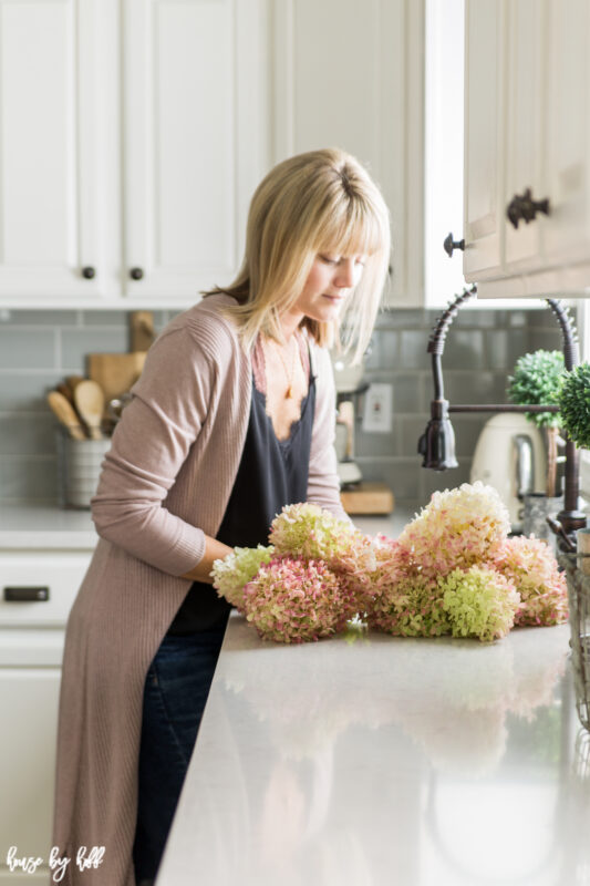 Pink Hydrangeas in the Sink of a Gray and White Kitchen being separated by April.