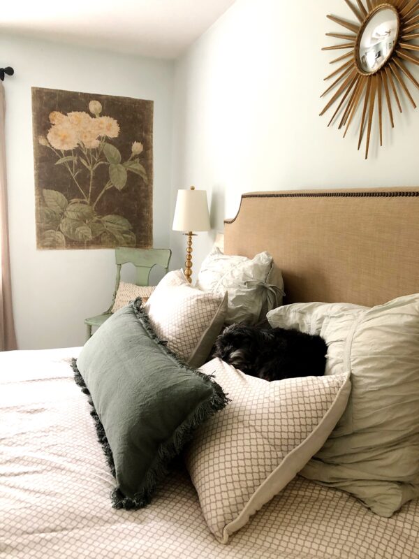 A neutral bed filled with pillows.