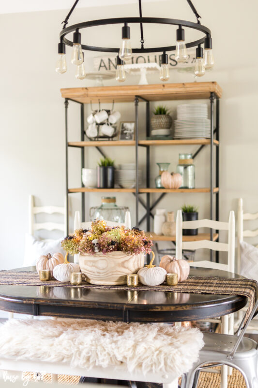 Easy Halloween Centerpiece with Skeletons and Spiders on a wooden dining room table.