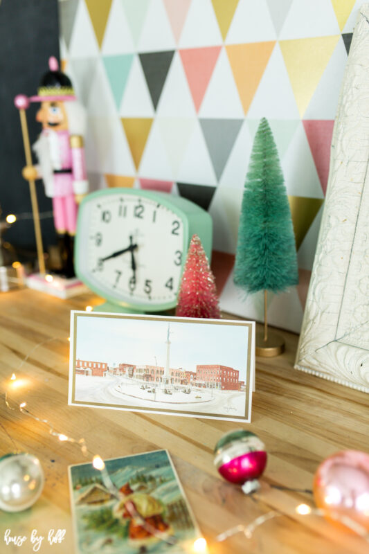 Vintage holiday postcards are on the desk beside the clock.