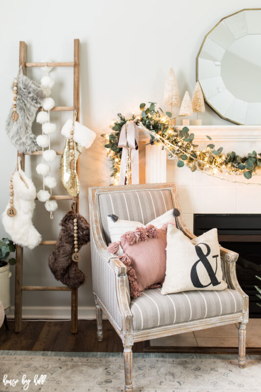 A vintage ladder leaning against the wall with Christmas stockings on it.