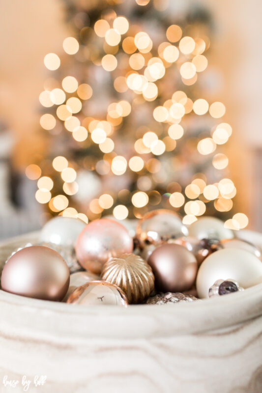  Rose Gold and Cream Ornaments are in a bowl on the coffee table.