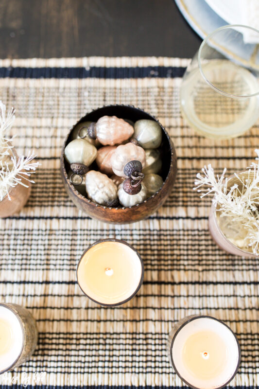 Gold and Pink Mercury Glass Ornaments in a Gold Bowl in the middle of the table.