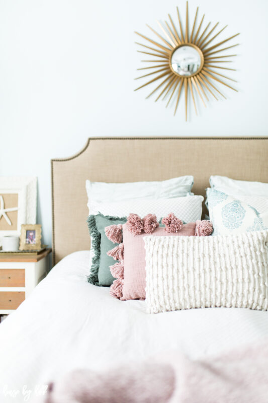 Master Bedroom with Upholstered Headboard, Starburst Mirror, and Pink Accents