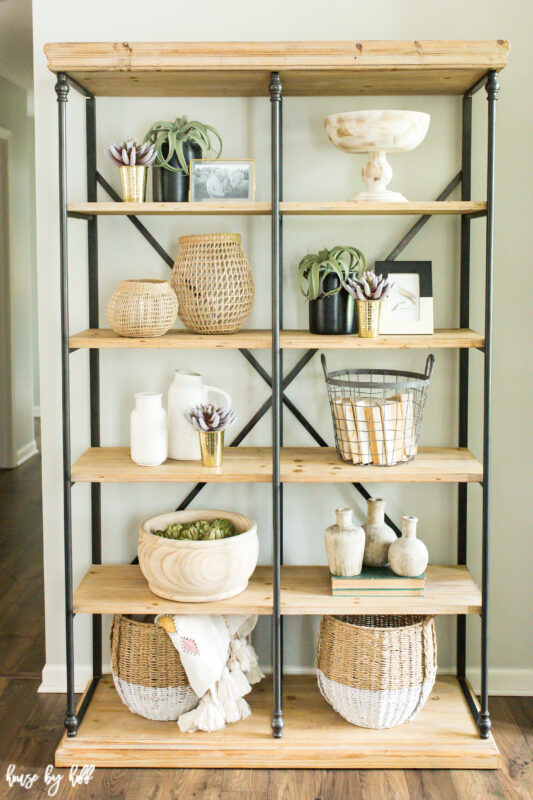 Wicker baskets are on the bottom shelf in the living room.