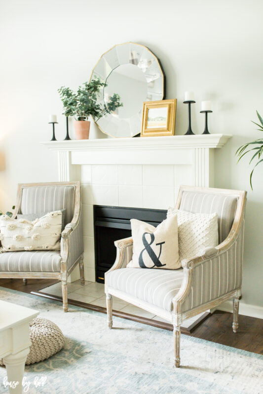 Two neutral armchairs flanking the fireplace.