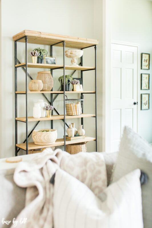 There are baskets and bowls on the open shelves.