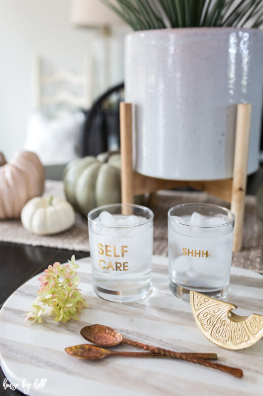 Gray and white striped cutting board with copper spoons and tumblers