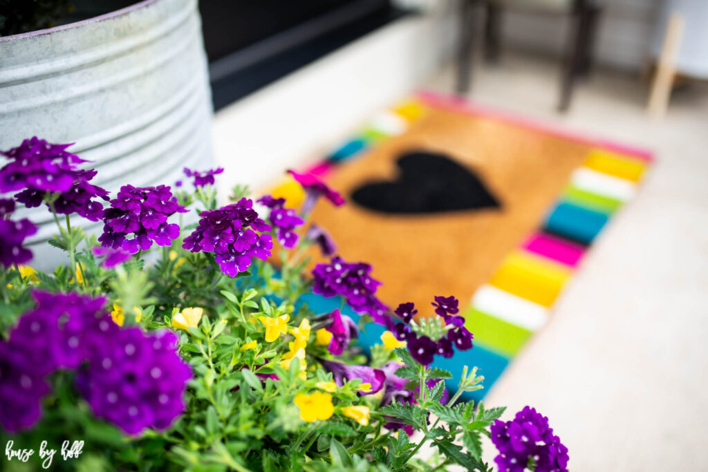 Multicolored flowers and mat on front porch