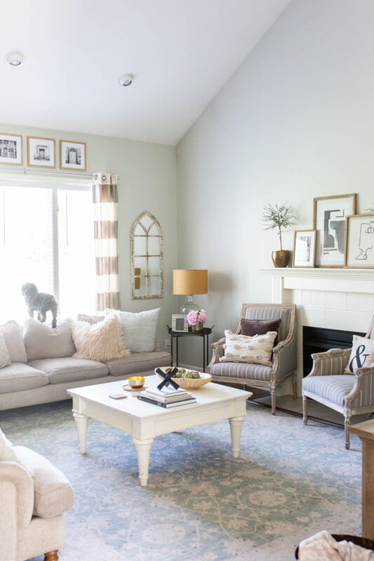 Neutral living room with black and white artwork on mantel