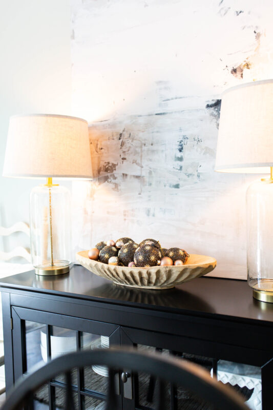 Black and Gold Ornaments in Wood Bowl with Abstract Art