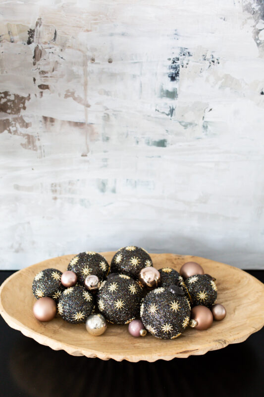 Black and Gold Ornaments in Wood Bowl with Abstract Art