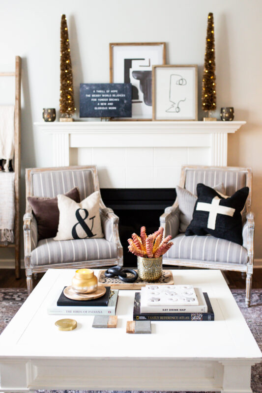 White Mantel with Black and Gold Holiday Decor and Ratan LED Light Trees