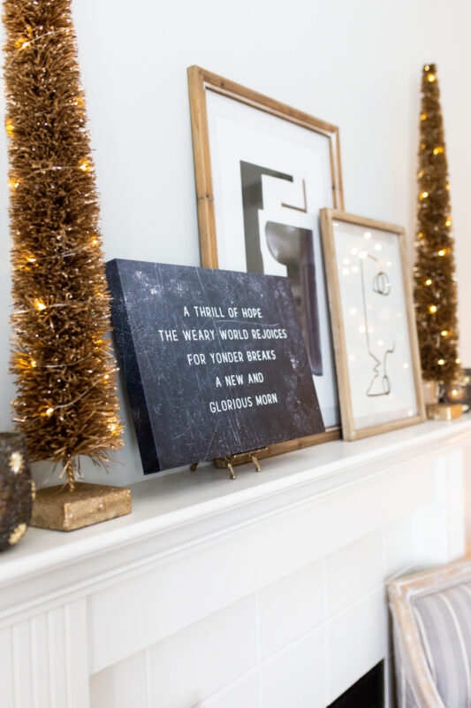 White Mantel with Black and Gold Holiday Decor and Ratan LED Light Trees